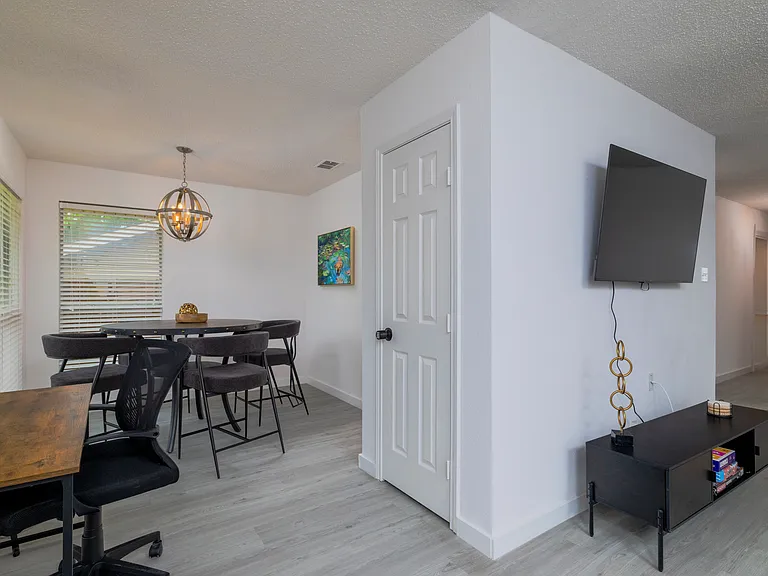 Dedicated workspace with ergonomic chair and wooden desk off of the living room and dining area.