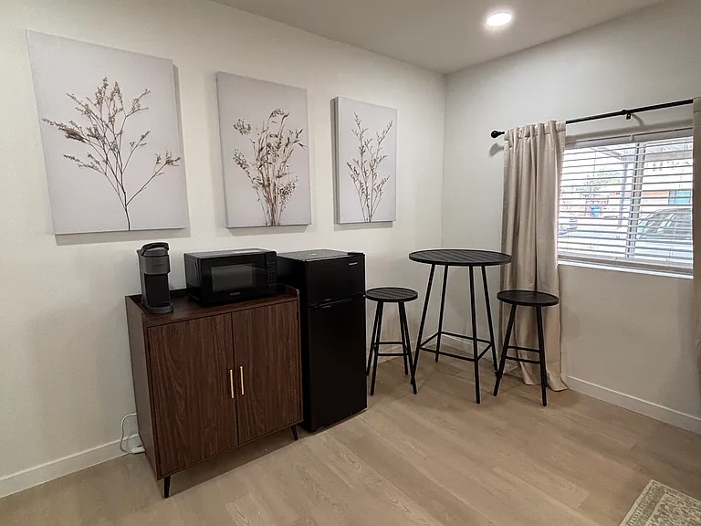 In-room kitchenette: Keurig, microwave, and mini-fridge, with a cafe table and stools for two