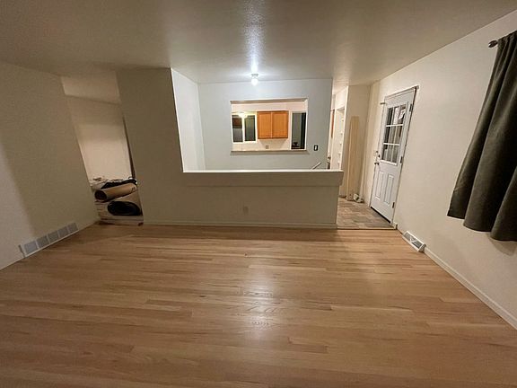 Living room looking to kitchen and side door dining room on left