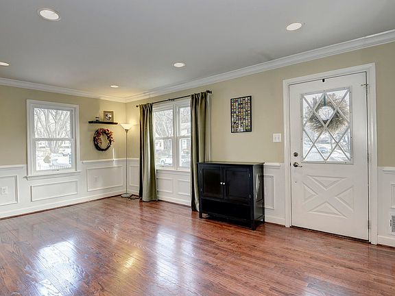 Large living room with crown molding and wainscoting