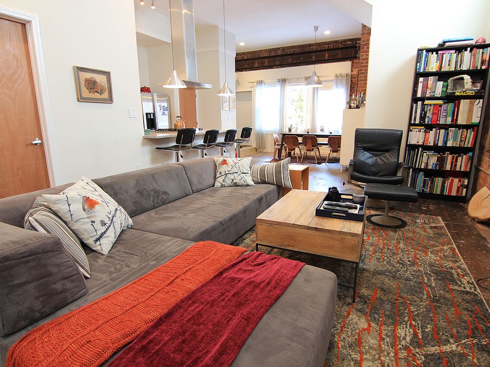 Property is Unfurnished. Open living room concept to kitchen, 12 ft ceilings, exposed brick.