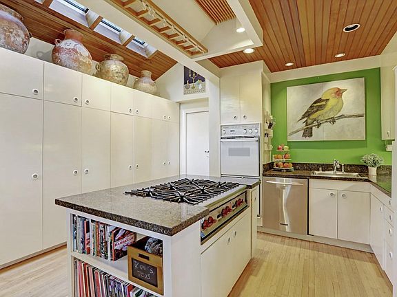kitchen with large skylight, desk area and many solid wood built-ins