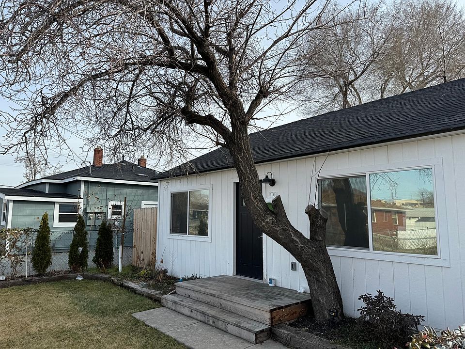 Fenced front yard, landscaped, with small deck.