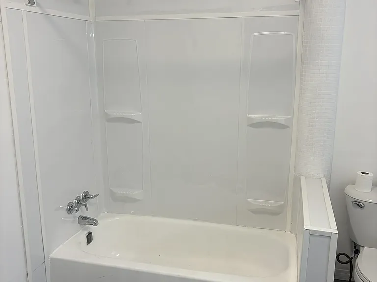 Updated bath NEW vanity, sink, light, flooring and tub surround