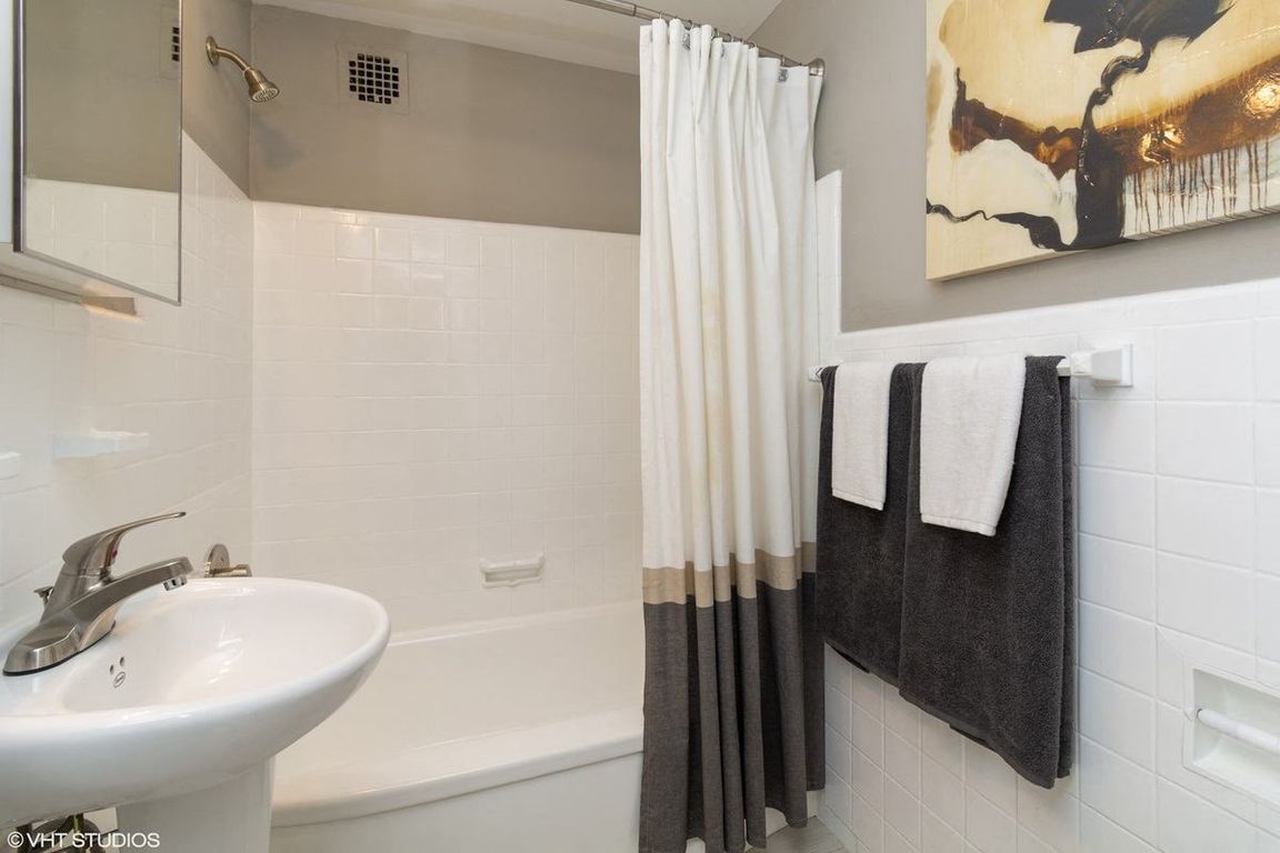 One bedroom model bathroom with sleek white tile