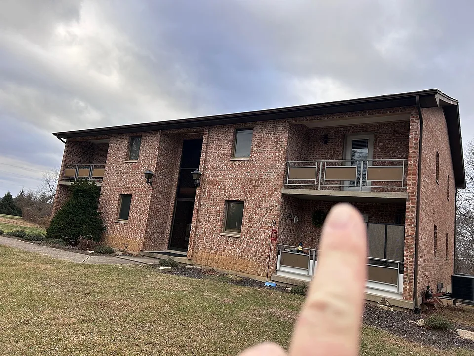 Front of building pointing at upstairs available unit