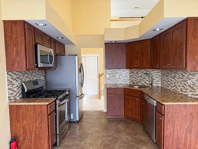 Another view of the Kitchen to the Hall & stairs to Loft.