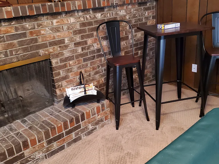 hi-chairs, hi-table, brick fireplace, tools, walnut paneling, raised brick hearth