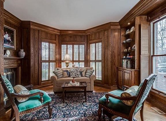 Inviting main floor study/office with wonderful bay window, built-ins and traditional gas fireplace