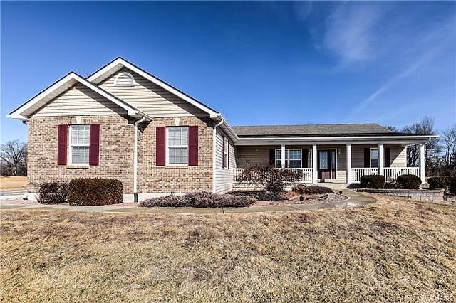 Beautifully landscaped entrance with covered front porch