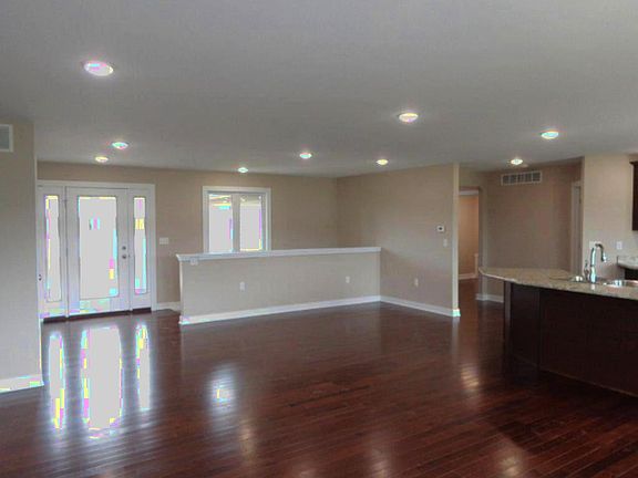 Delightful open floor plan and gorgeous wood flooring in living room, kitchen, dining area and laundry room. Open staircase to lower level. Neutral colors throughout.