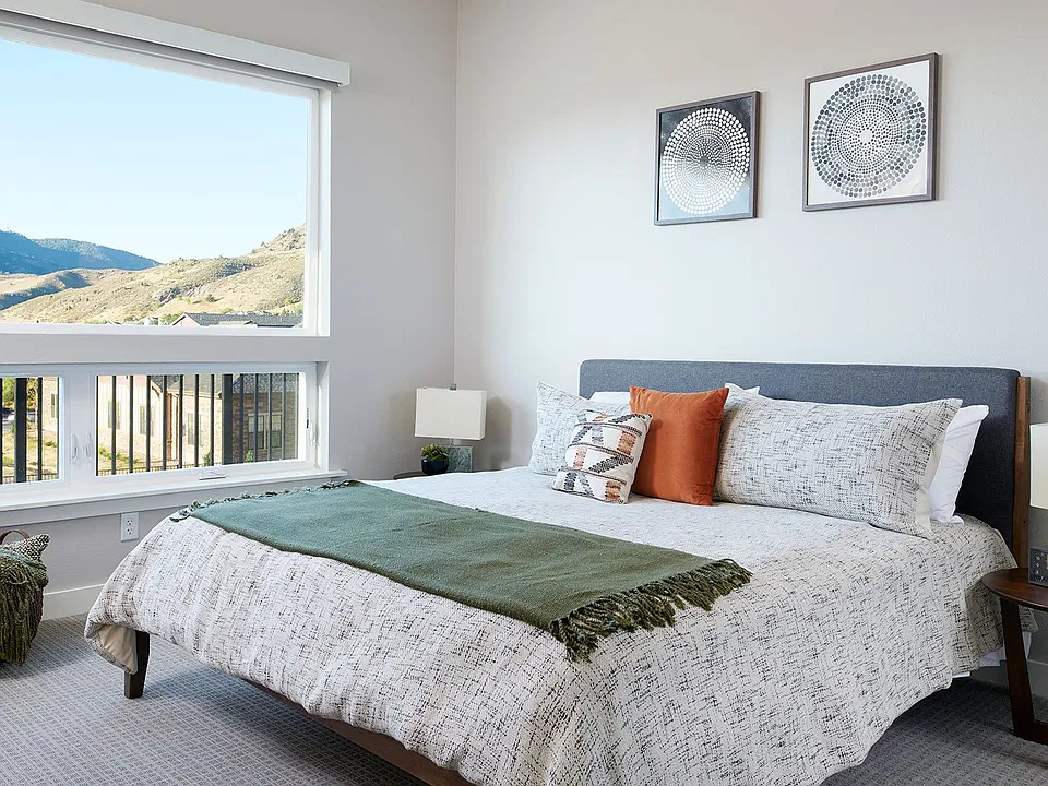 A bright bedroom with oversized windows brings natural light and sweeping foothill views into the everyday experience of living at Epoque.