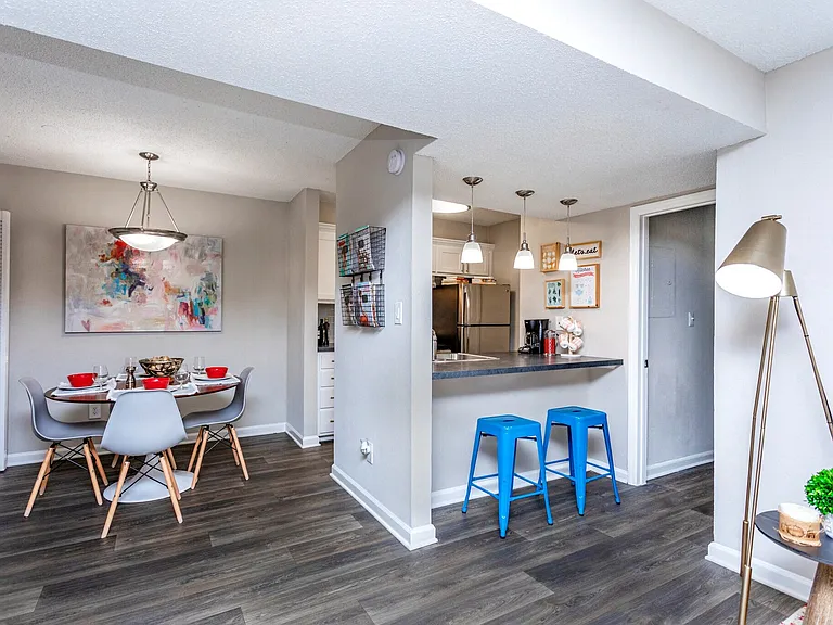 Open-concept dining space with breakfast bar and modern flooring.