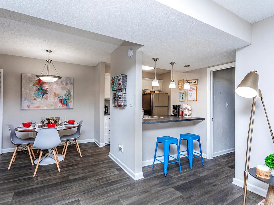 Open-concept dining space with breakfast bar and modern flooring.