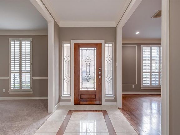 The dramatic entry. The formal dining room is to the left and the living room to the right. Notice the plantation shutters.