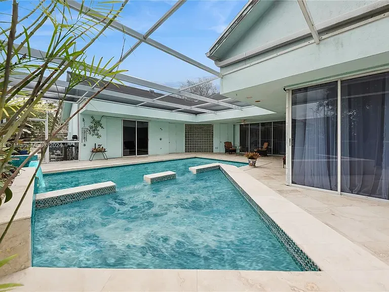 Screened pool and spa surrounded by the home