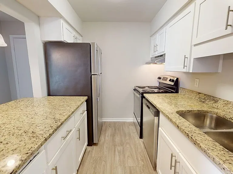 Modern kitchen with sleek granite countertops, stainless steel appliances, and elegant white cabinetry. Modern kitchen with sleek granite countertops, stainless steel appliances, and elegant white cabinetry.