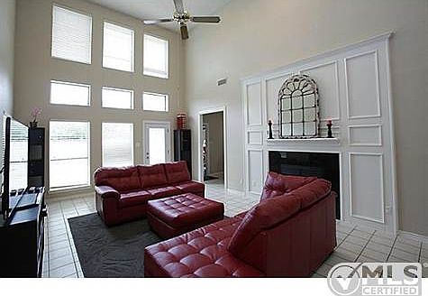 family room with wall of windows & ceiling fan