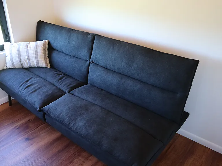Futon/sofa bed can lie flat for guest/visitor.
