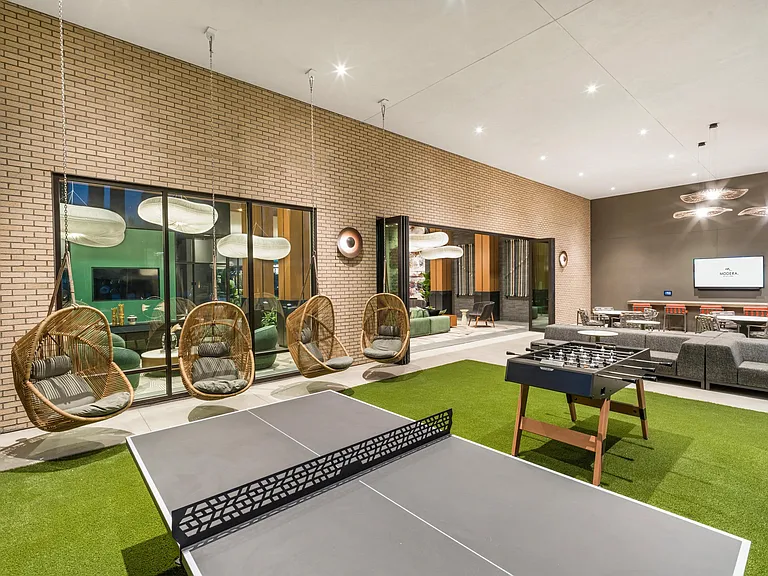 Challenge friends to a round of ping-pong or foosball, then kick back in hanging loungers_all under the glow of designer lighting in this stylish indoor-outdoor social space.