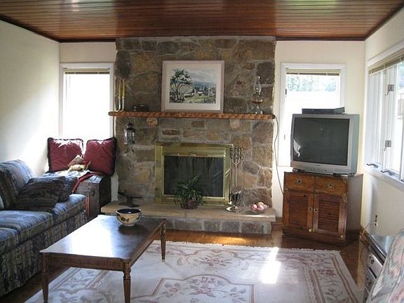 Family room with stone fireplace and wall of windows