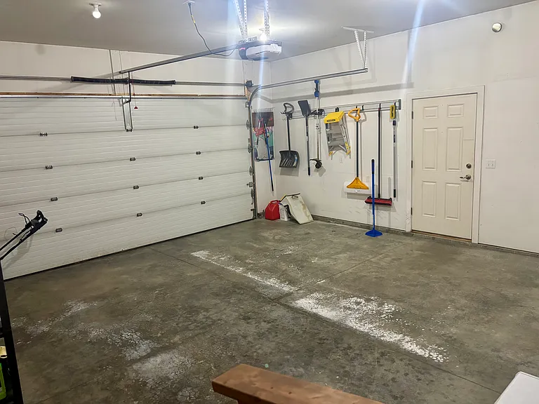 Two-car garage supplies all garden and snow tools, snowblower, mower, shelving for storage and a small freezer