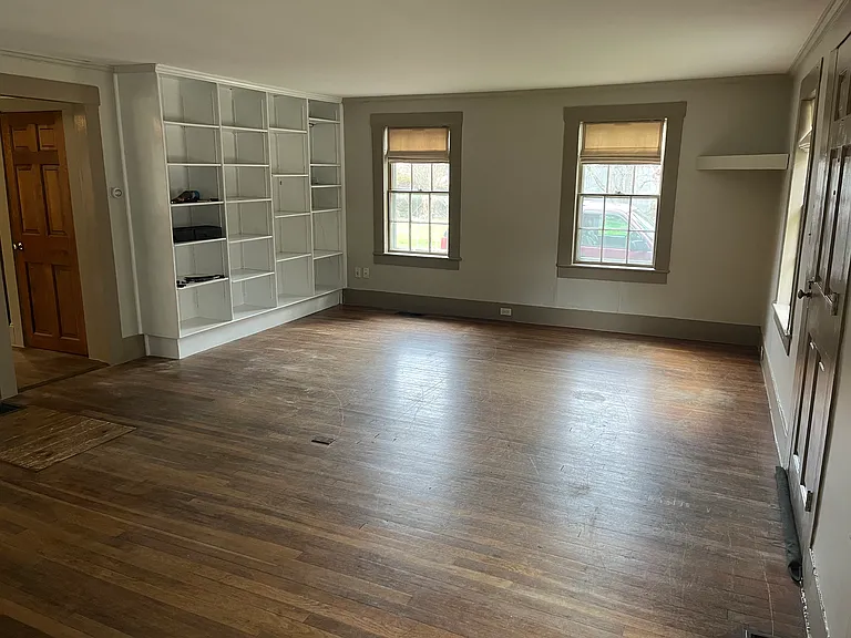 View of living room bookcases and custom window treatments