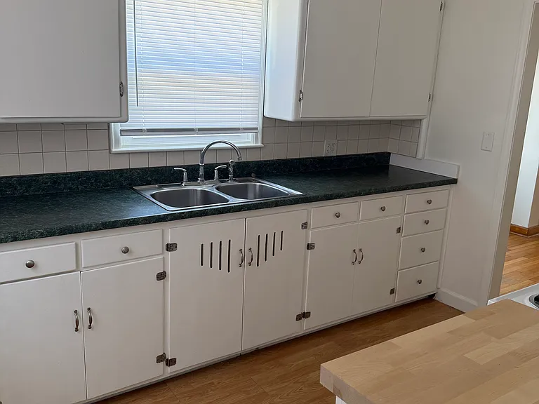 stainless steel sink with garbage disposal, tile backsplash and new windows with new blinds
