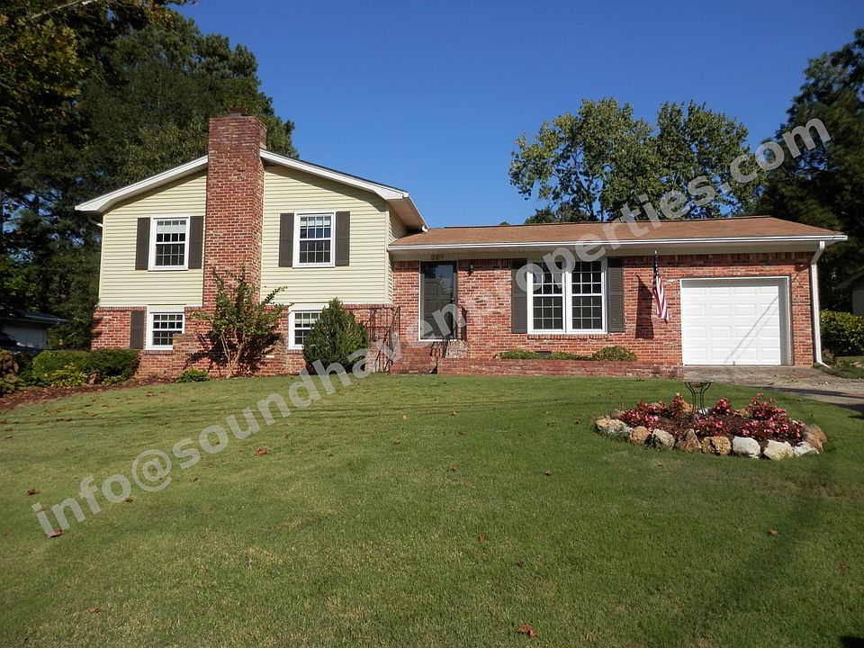 Curb appeal with stacked stone, landscaping, and double driveway.