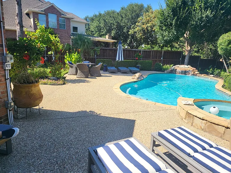 Picturesque and expansive private backyard with pool, waterfall, and mature landscaping