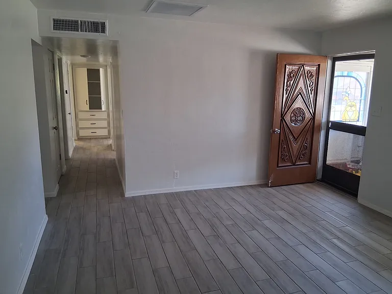 Living room with hallway leading to three bedrooms