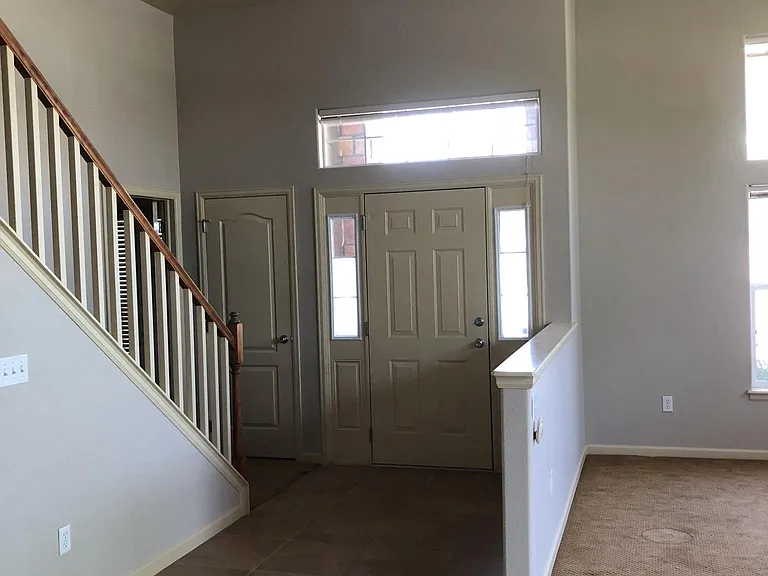 Looking at the entry, leading from the kitchen to the primary suite to the left.