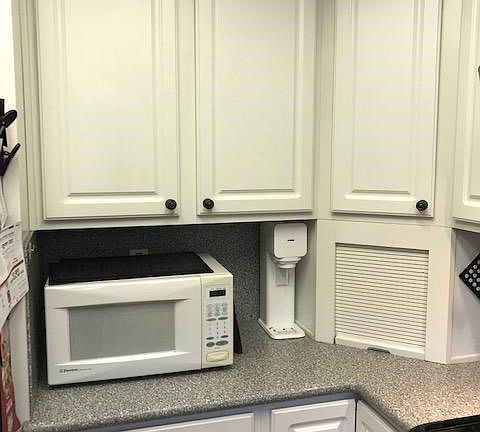 The microwave also stays.  Notice the appliance garage cabinet...