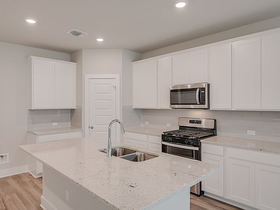 The Elemental design package features white cabinets, granite countertops, and brown EVP flooring.