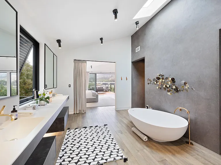 Enjoy a relaxing bubble bath while sipping on a glass of campaign in this luxurious bathroom.