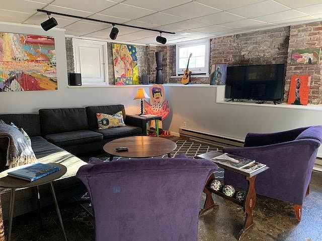 Ample loft style living room with cable TV and exposed brick wall features