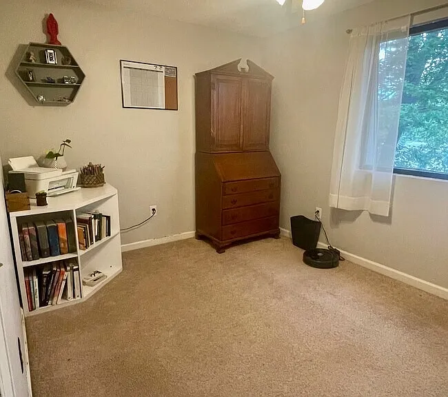 Second bedroom or office with carpeted flooring, natural light, and closet space.