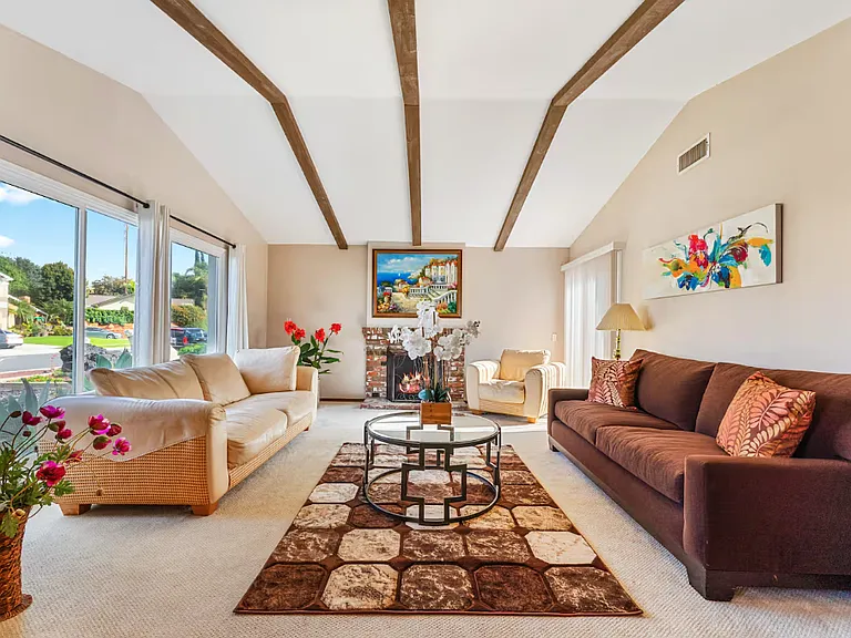 This beautiful living room in great cathedral ceiling shows lots of natural light into the home. A sliding door is on your right . The sliding door opens to the side backyard. Another picture shows this side backyard.