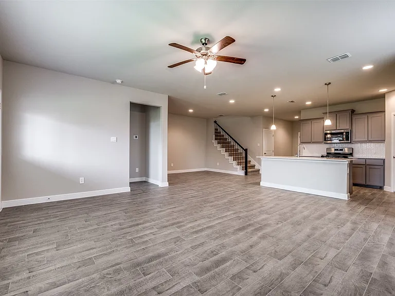 Unfurnished living room featuring ceiling fan, light hardwood / wood-style flooring, and sink