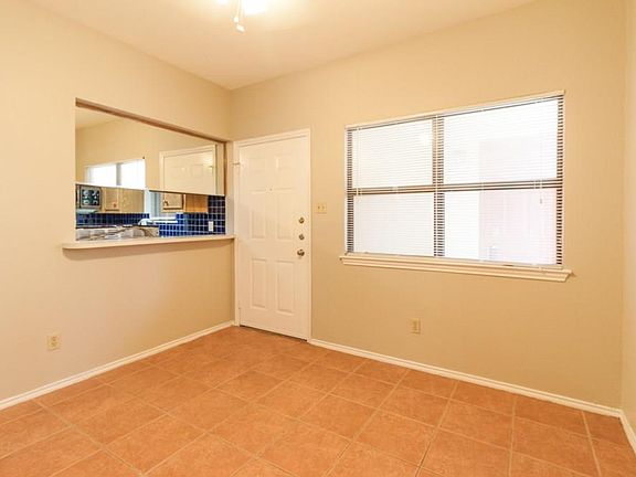Living room view of front door & kitchen bar