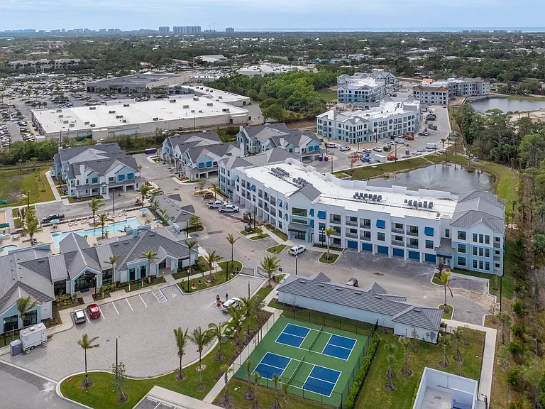 Imperial Crossing Luxury Apartment Homes community aerial view showing buildings, parking, outdoor court, and more.