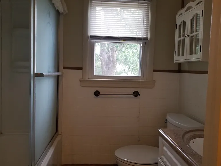 Toilet and sink on right.
Bathtub on left.
Window faces backyard.