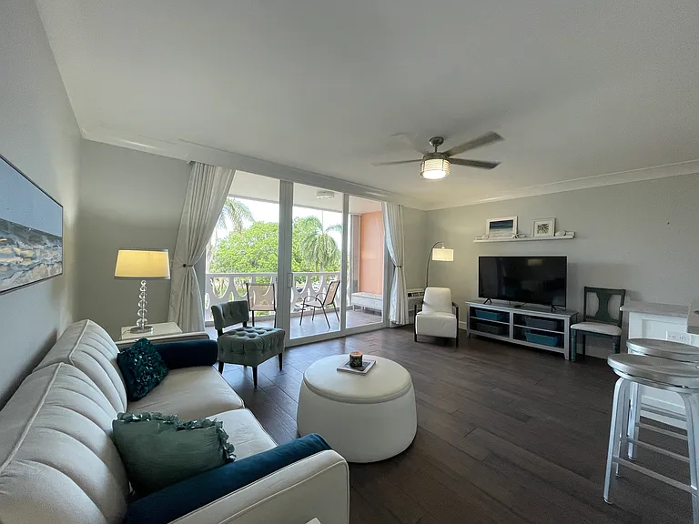 Spacious living room with relaxing view of the park and waterway. Floor to ceiling glass sliding doors with hurricane doors.