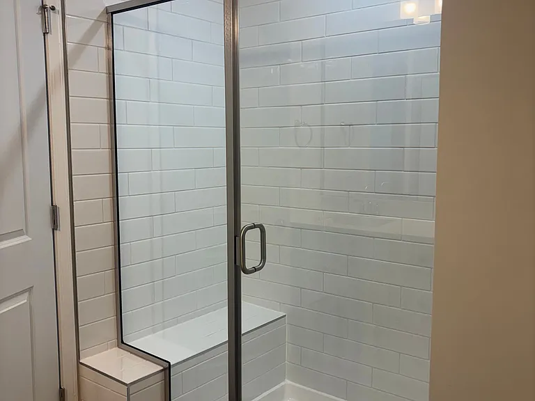 Spacious shower area with seating.