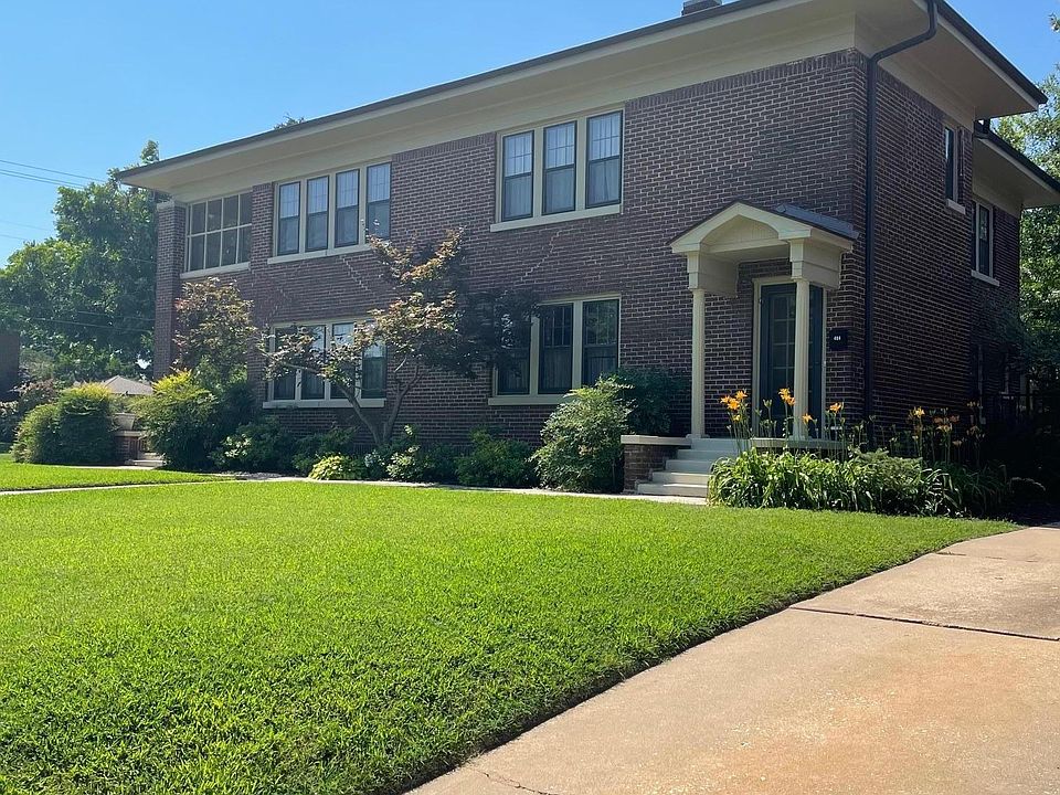Front door for 404 the upstairs unit. Lovely well maintained yard with mature foliage.