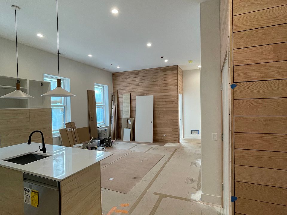 In-progress photo of kitchen/living room, taken from the entry way. Features wood walls.