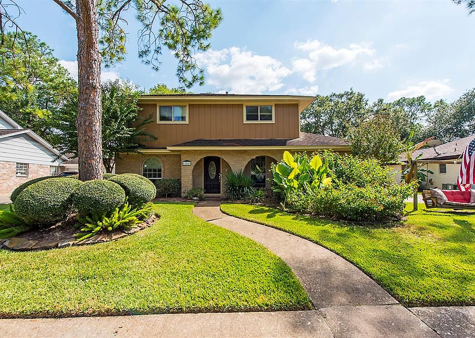 Beautifully landscaped front yard with inviting swing.