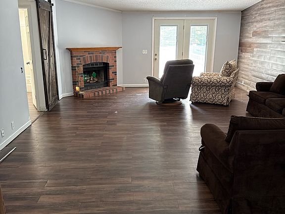 Large living space with sliding barn door that leads to 2 spare bedrooms and spare bathroom