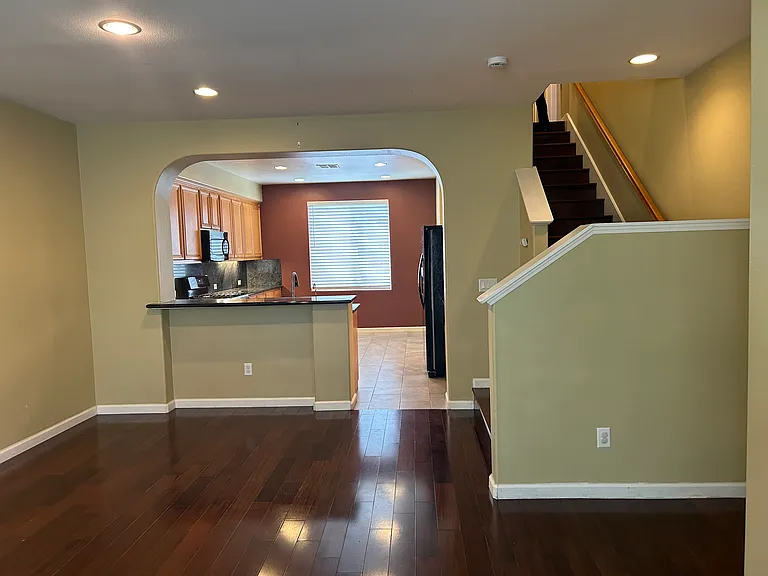 VIEW FROM LIVING ROOM TO KITCHEN AND UPSTAIRS