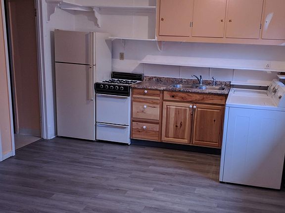 Kitchen and dining area, with washer and dryer at right. The oven and stove are gas. The refrigerator has a separate freezer compartment above. There is now a microwave on the shelf above the stove, not shown in this photo.